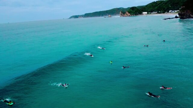 白波が綺麗で波にのるサーファーを早朝に空撮 4K