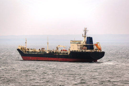 Ein Tanker liegt bei diesigen Wetter vor Anker