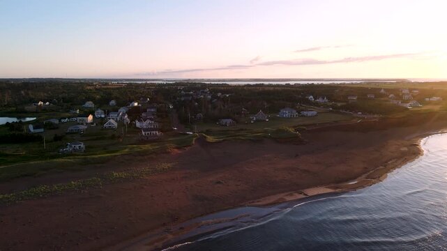 Red sand dunes and coastline of Prince Edward Island at sunset, aerial shot