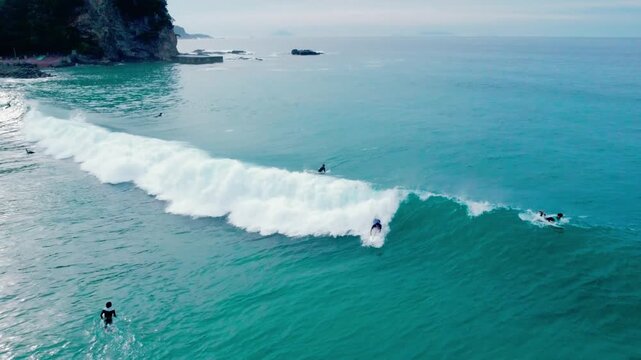 白波が綺麗で波にのるサーファーを早朝に空撮 4K
