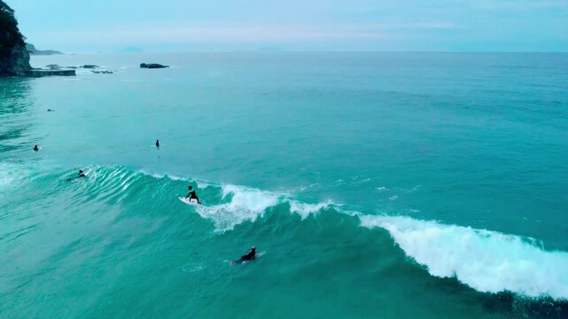 白波が綺麗で波にのるサーファーを早朝に空撮 4K
