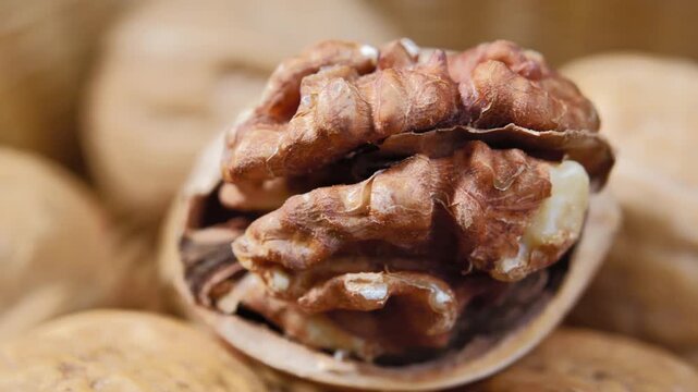 Fresh organic walnuts in a rustic wooden bowl on a wooden table. Healthy natural nuts rich in nutrients, suitable for healthy eating, snacks, and food backgrounds.