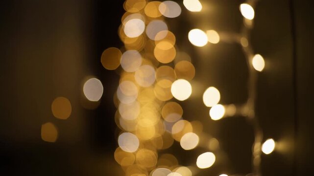 Warm golden bokeh string lights gently swaying, creating a festive and magical atmosphere, ideal for holiday celebrations and special events, symbolizing joy, warmth