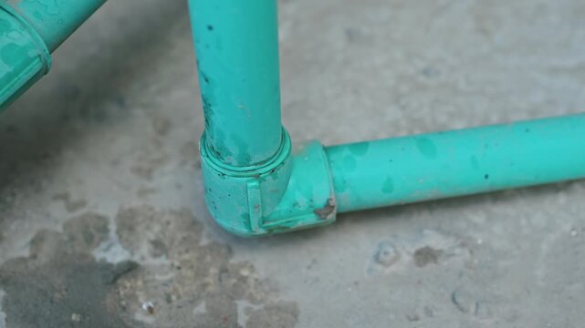 Close Up of Green PVC Pipe Elbow Joint Plumbing Connection