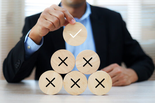 Hand choose check mark with cross symbol on wooden toy stack for true or false changing mindset or way of adapting to change leader and transform quiz answer and poll concept.
