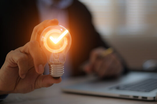Businessman's hand is choosing light bulb for business creativity plan to goal or creative idea innovation or analyzing marketing data management and target growth or human resources.