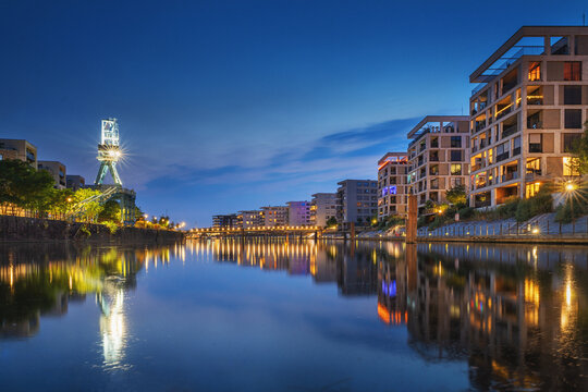 Modern new build properties by the water in Offenbach am Main harbor bey night, Hesse: Development of a new residential area in a city with condominiums and apartments