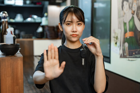 鍵を持ちストップをする女性