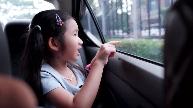 Asian Child Wearing Seat Belt While Drawing in Car During Family Road Trip, Safe Travel and Child Passenger Safety Concept