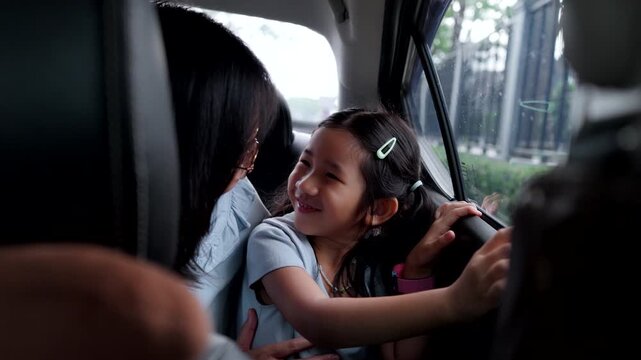 Asian Child Wearing Seat Belt While Drawing in Car During Family Road Trip, Safe Travel and Child Passenger Safety Concept