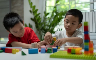 Fototapete Lego Preschool Children Learning Through Play with Colorful Wooden Blocks and Educational Toys at Home, Promoting Cognitive Development, Fine Motor Skills, Creativity, Teamwork and Focus.  © Father_Studio