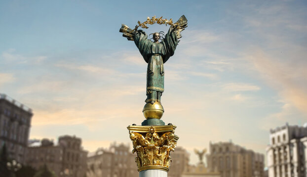 The Independence Monument in Kyiv and Maidan Street illuminated by warm sunset light against a colorful evening sky, representing Ukraine freedom, heritage and enduring spirit. Not AI