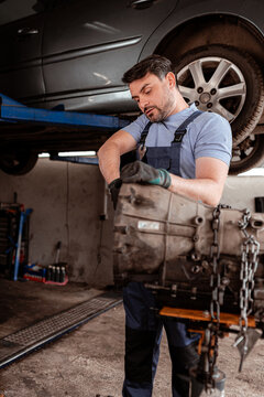 Mechanic works on car engine at auto repair shop in the daytime