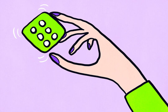 Hand holds a green dice in front of a purple background while rolling it for a game or decision