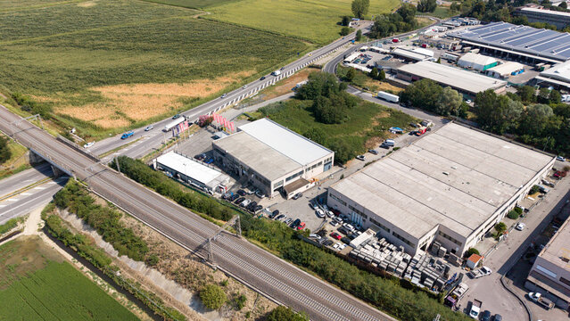 Industrial Area Aerial View: An aerial perspective showcases a sprawling industrial zone with warehouses, roads, and surrounding greenery, highlighting the infrastructure of a manufacturing hub.