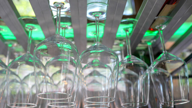 Inverted glasses draining at restaurant after washing in professional kitchen setup
