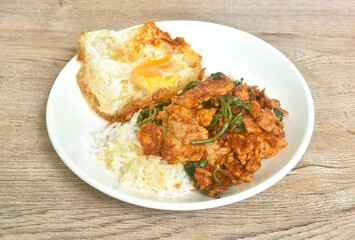 Fototapeta premium spicy stir fried slice pork meat with chili and basil leaf curry topping egg and rice on plate