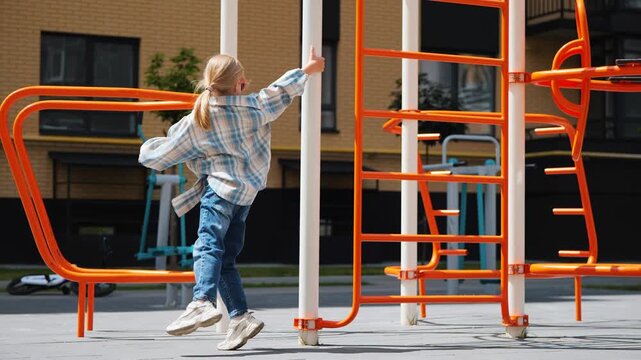 Stylish Blonde Girl Dancing On Playground Bars In Modern Courtyard