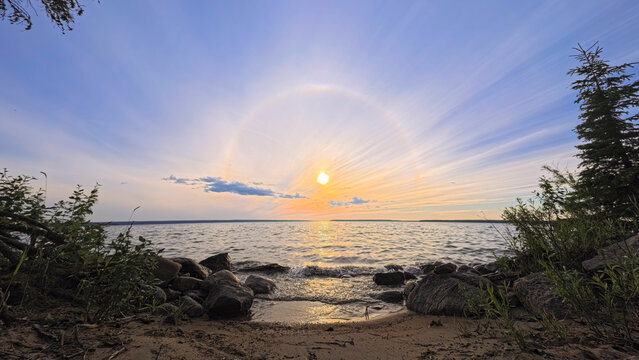 Evening Sun Halo Over a Calm Waskesiu Lake and Rocky Beach