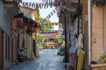 Fototapeta premium Narrow tourist street decorated with international flags in horizontal view