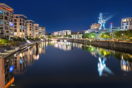 Modern new build properties by the water in Offenbach am Main harbor bey night, Hesse: Development of a new residential area in a city with condominiums and apartments