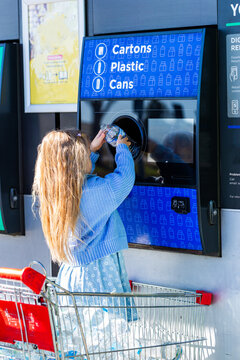 child returning plastic bottle for recycling at return and earn collection point in Australia