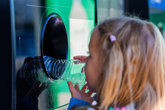 child returning plastic bottle for recycling at return and earn collection point in Australia