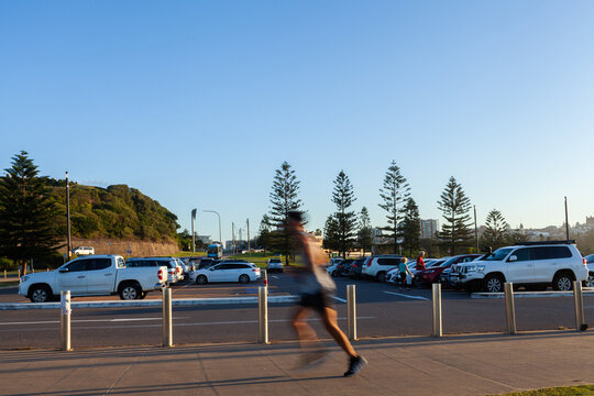 Motion blur of person jogging along walkway in Newcastle recreation area