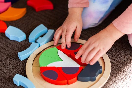 kid playing with wooden ladybird puzzle motor skills development toy