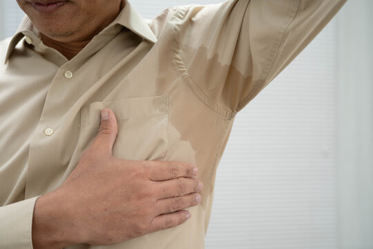 Man with sweaty arm pit on shirt when working in office, Hyperhidrosis sweating.