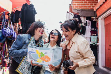 Obraz premium senior latinas friends women travellers in tourist market in Mexico Latin America, hispanic middle age females shopping in vacations 