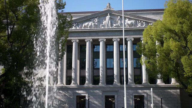 People can see the California State Office Building on the State Capitol campus in Sacramento with clear blue skies and trees.