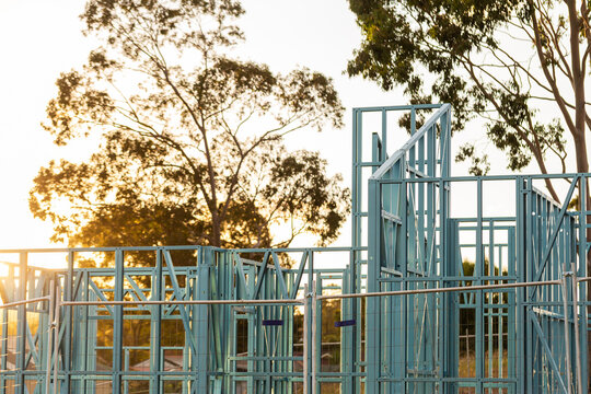 Blue steel frame of house under construction in Australian suburb at sunset