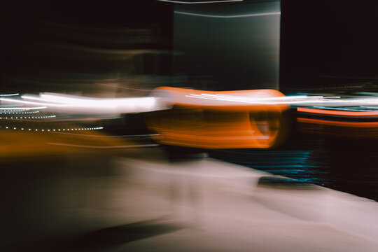 Blurred orange motion streaks glowing across dimly lit urban nightscape