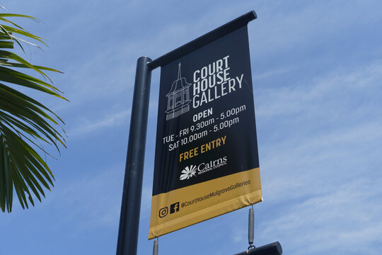 A banner advertises the Court House Gallery's free entry and opening hours on November 2, 2024 in Cairns, Australia.