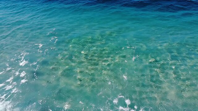 Beautiful Turquoise Ocean Wave Rolling Over Shallow Clear Sandy Coastline with Soft White Sea Foam Tropical Summer Nature Background