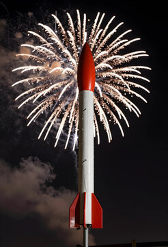 Firework rocket with exploding fireworks in night sky