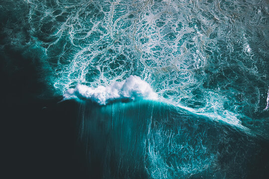 Aerial view of a single ocean wave as it crests and breaks