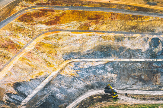 Aerial view of a terraced large open pit mine exposing earth layers
