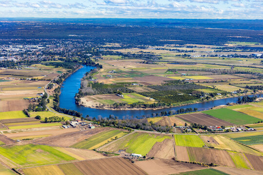 Aerial view of a patchwork farmland beside the meandering river