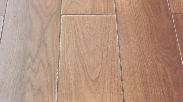 Camera tilting over brown wood grain floor tile texture