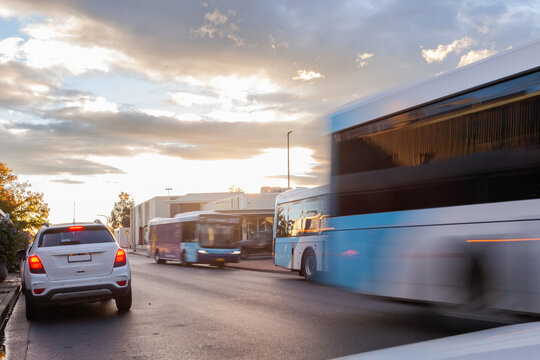 Motion blur of public transport busses traveling down road in Singleton at sunset