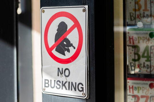 no busking sign on post outside shops