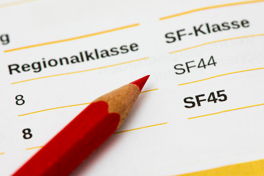 Ein Rotstift liegt auf der  Beitragsrechnung f&uuml;r Kfz-Haftpflichtversicherung mit Angabe der SF-Klasse