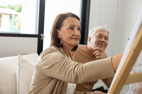 Middle age woman senior man painting canvas art home couple creative hobby indoor