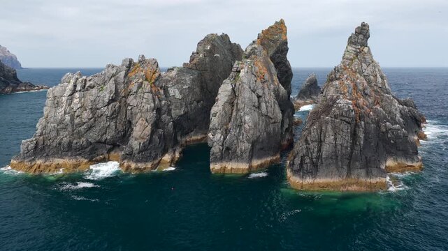 Aerial view flyover above rocks piercing through the Atlantic coast on the Coast of Galicia at Gabo Ortegal