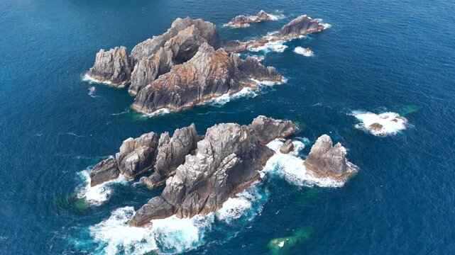 Aerial view flyover above rocks piercing through the Atlantic coast on the Coast of Galicia at Gabo Ortegal