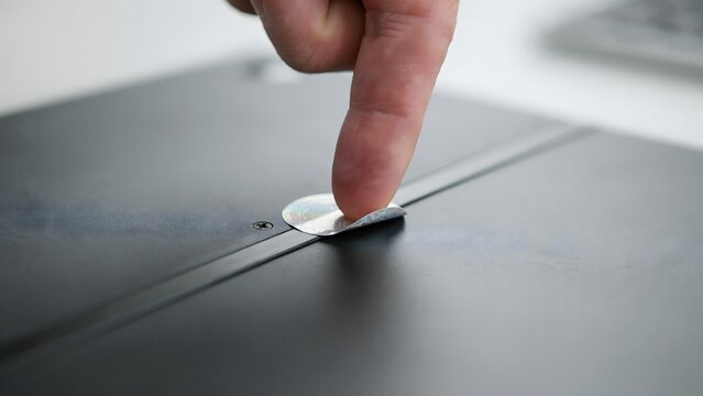 Close-up of a person's finger pressing a button on an electronic voting machine or control panel