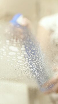 Female Person spraying glass table in slow motion