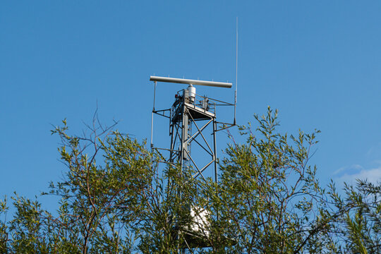 Marine radar antenna on a metal tower. Navigation system for ship traffic monitoring.